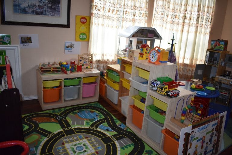 Playroom with toy storage shelves, a road map rug, and toys