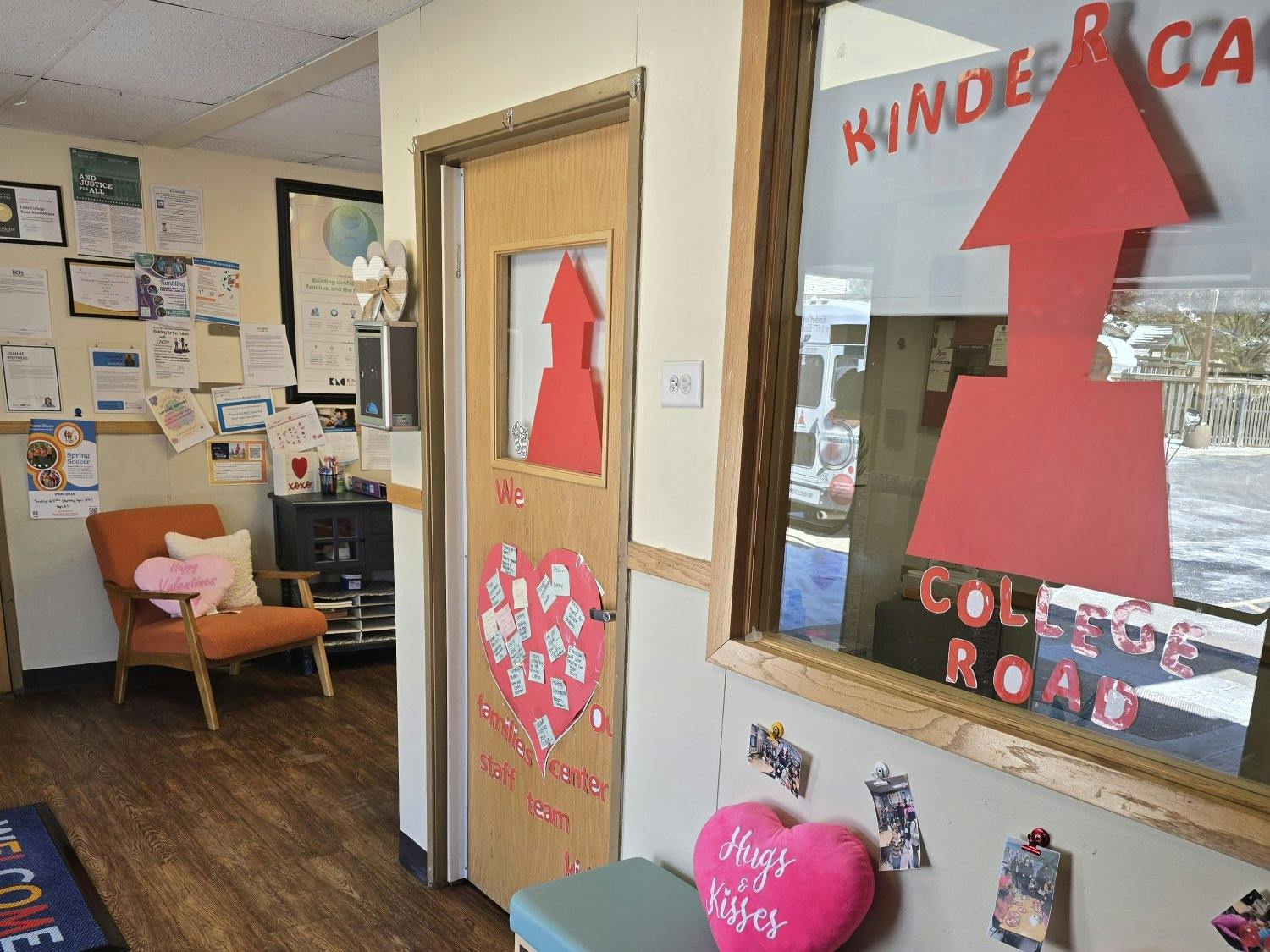 An office waiting area with an orange chair and a window with red lettering