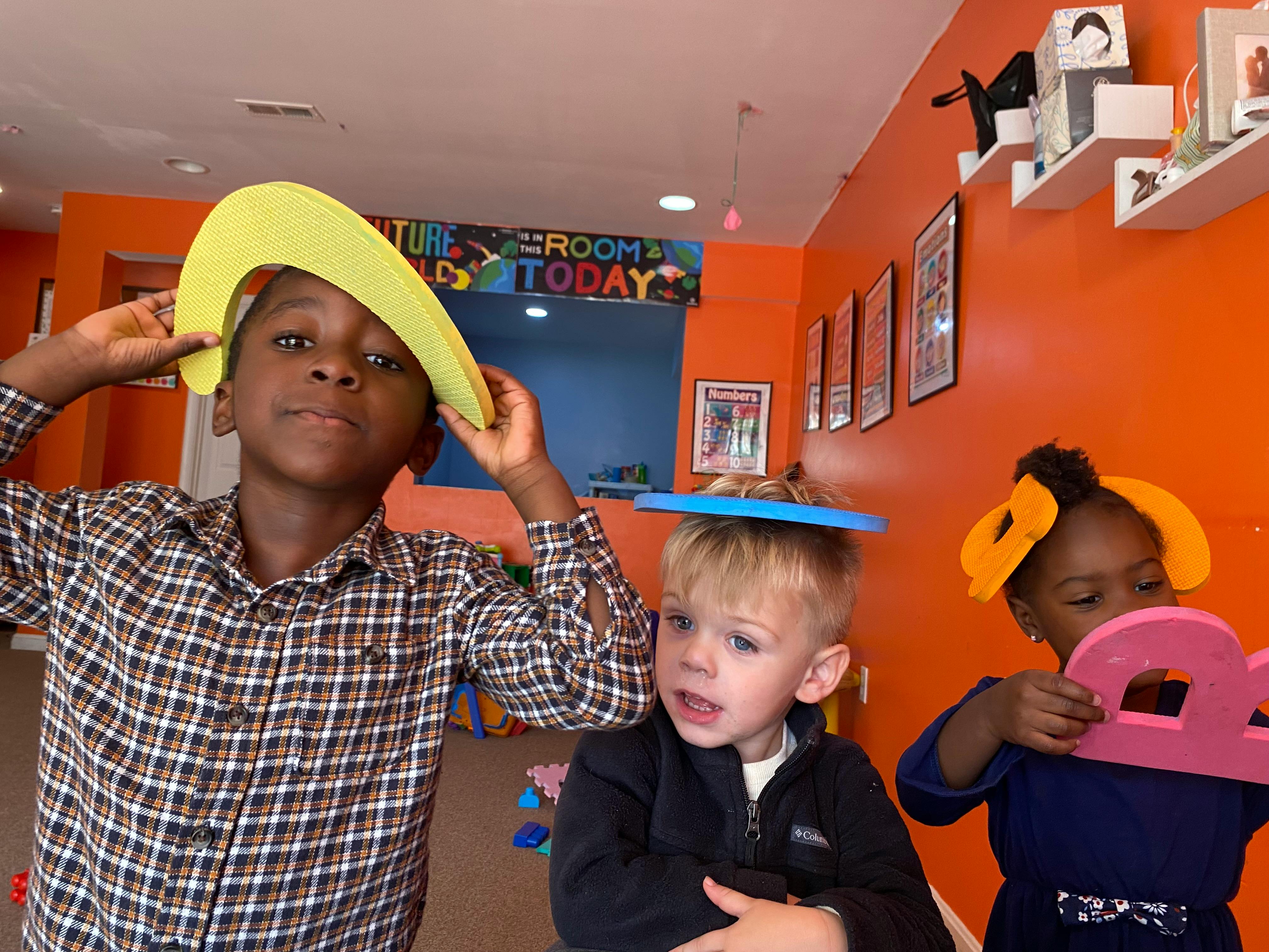 Three children playing with foam letters and numbers