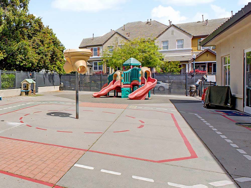 Empty playground with a slide structure and painted road lines on the ground
