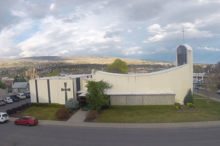 Modern church building with a cross on the facade and a tall steeple