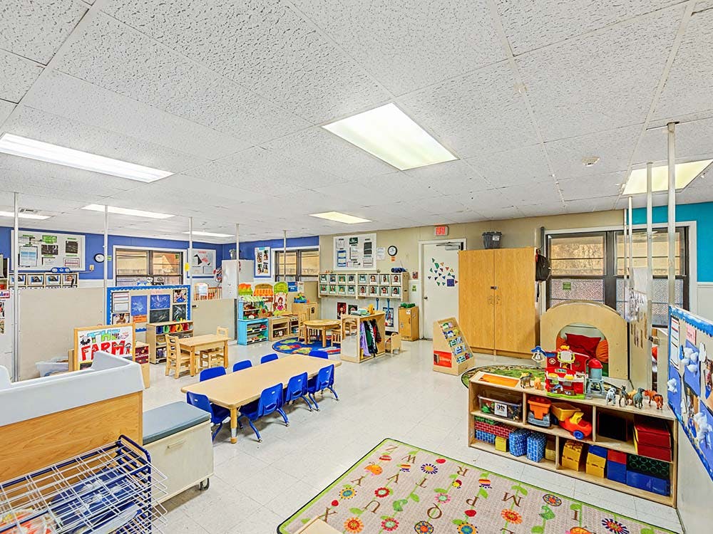Classroom with tables, chairs, learning materials, and toys