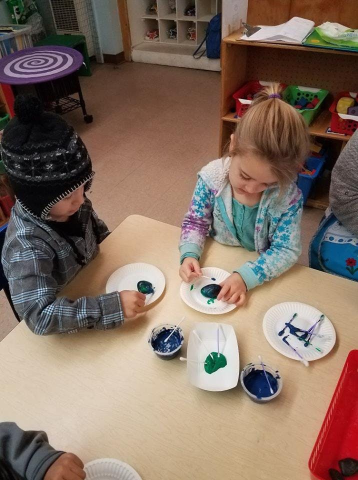 Two children painting at a table