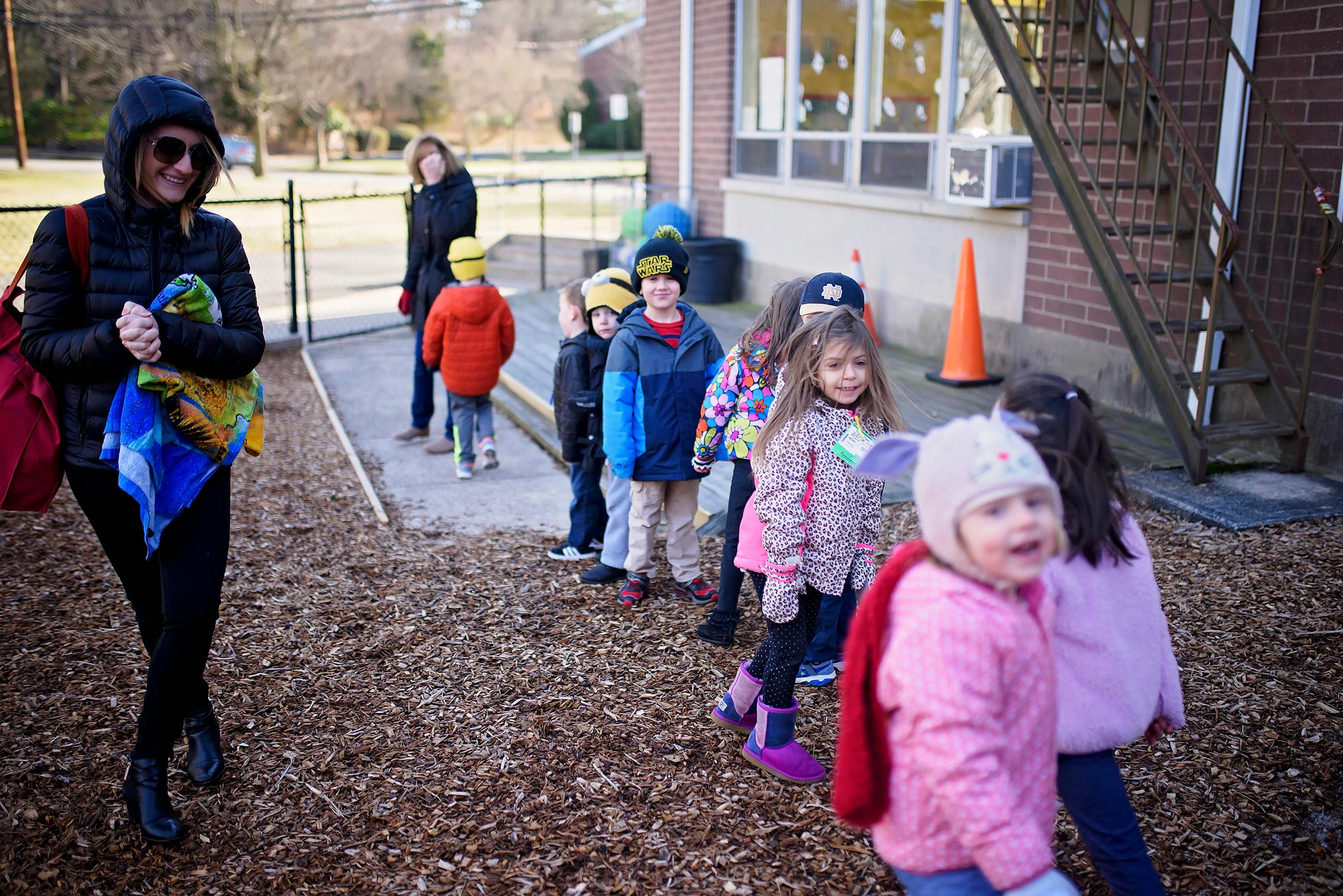 Adult and children walking in a line outdoors