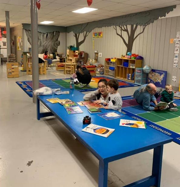 Adults and children reading books in a classroom