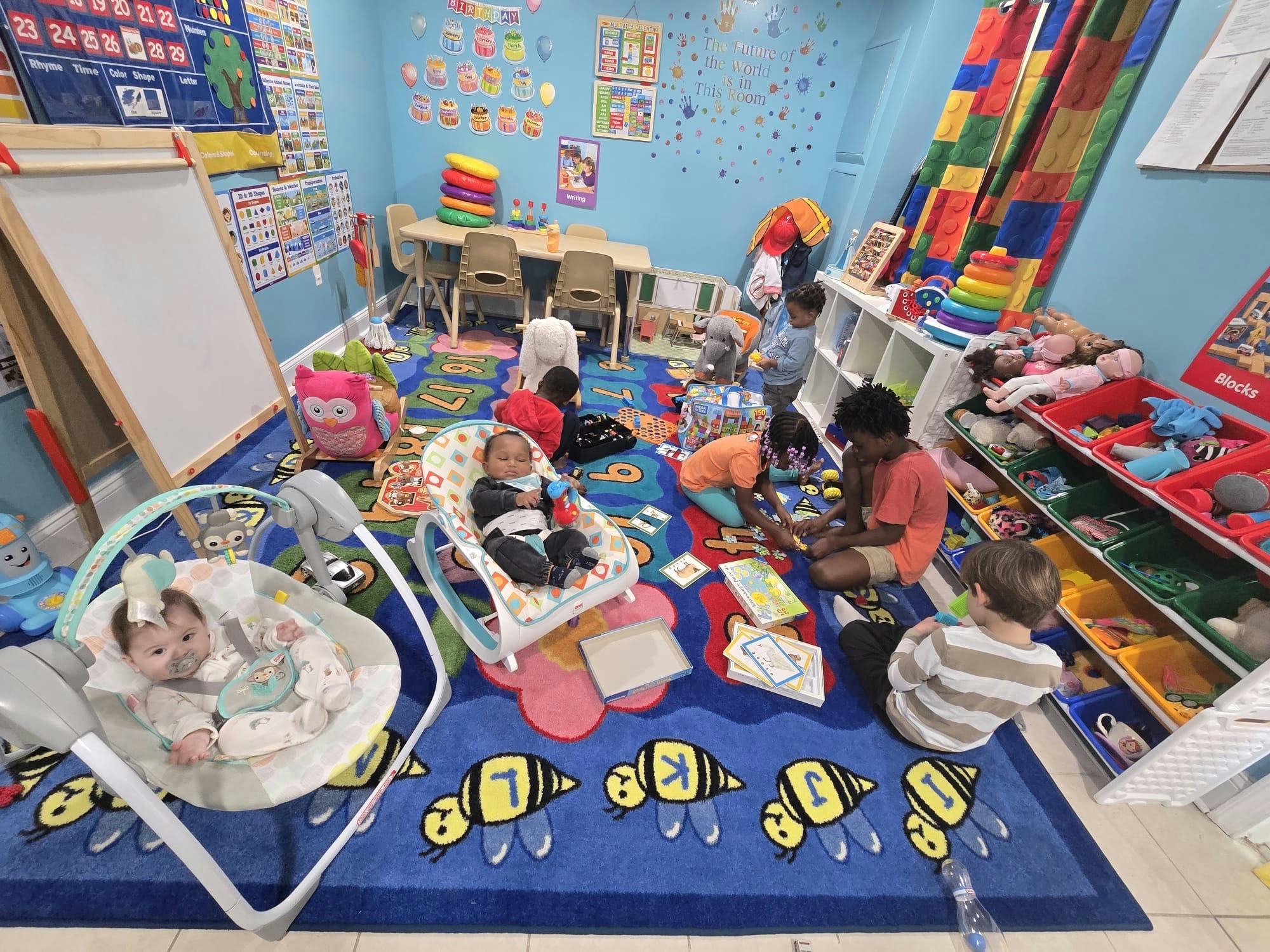 Multiple children playing on a colorful rug in a classroom