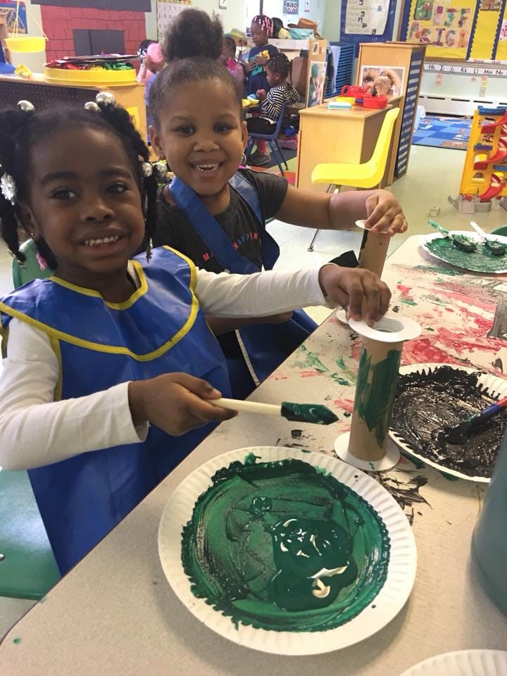 Two children painting at a table