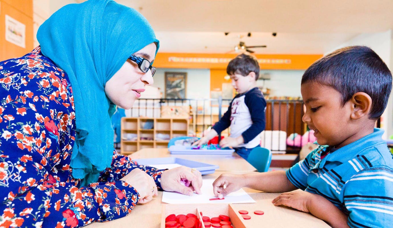 Person and child at a table with red counters