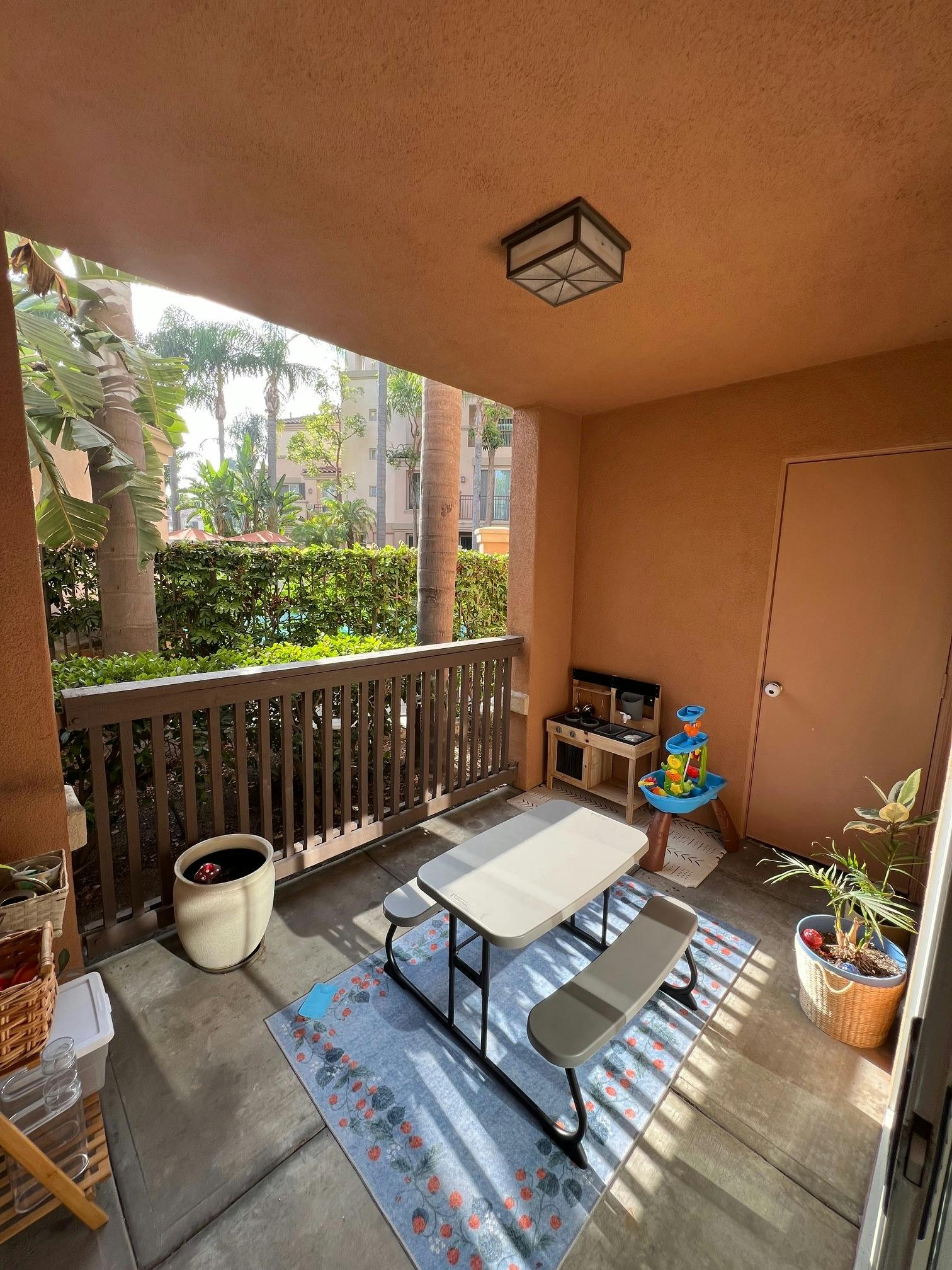 Patio with a small picnic table, rug, and children's play kitchen