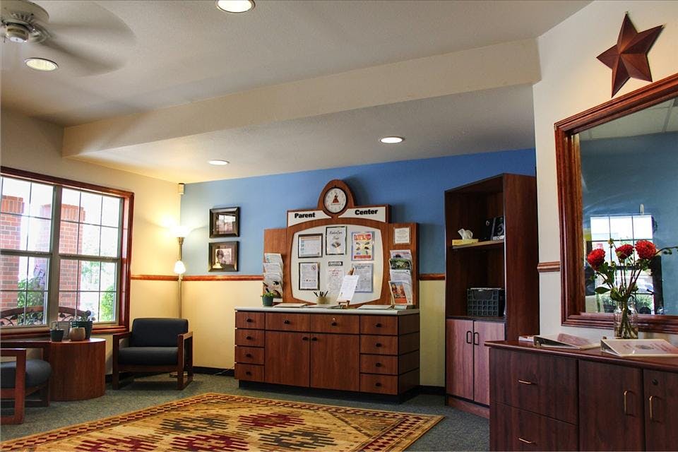Lobby area with a "Parent Center" bulletin board, chairs, and a window