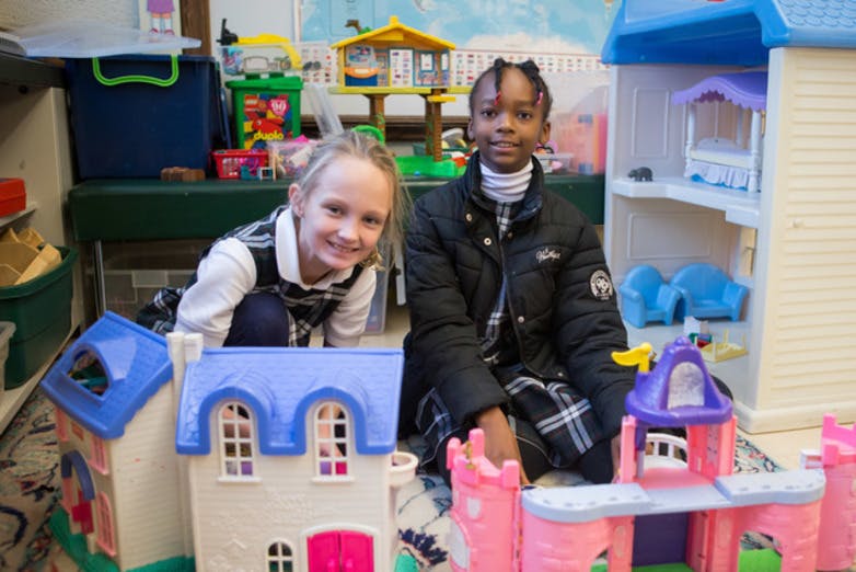 Two children playing with dollhouses