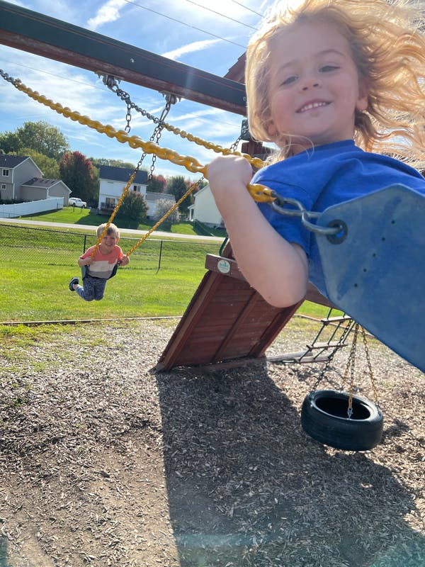 Two children on swings at a playground