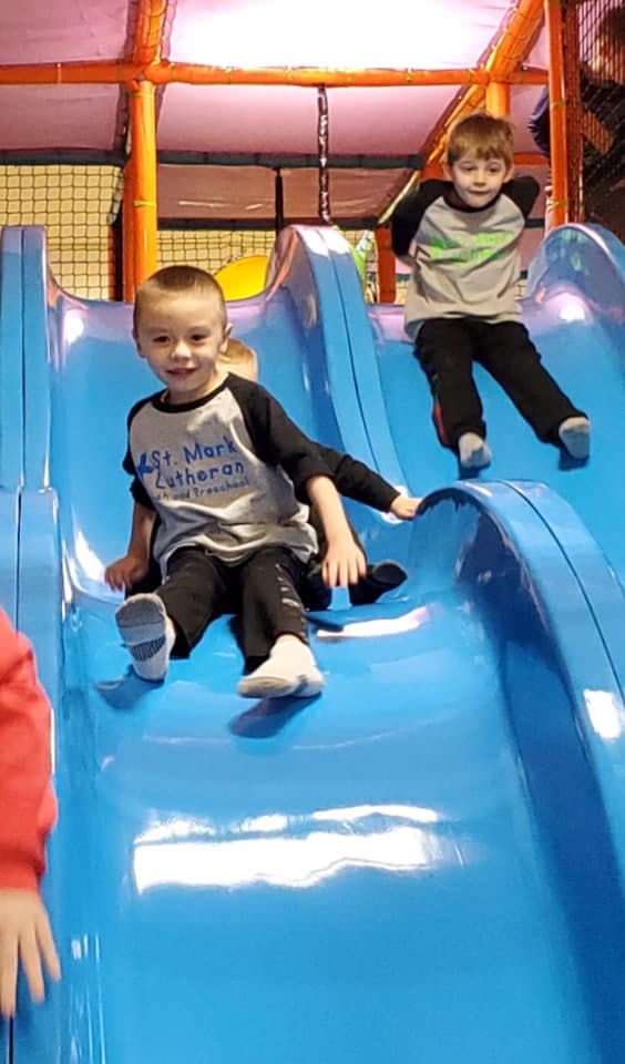 Two children on a blue slide