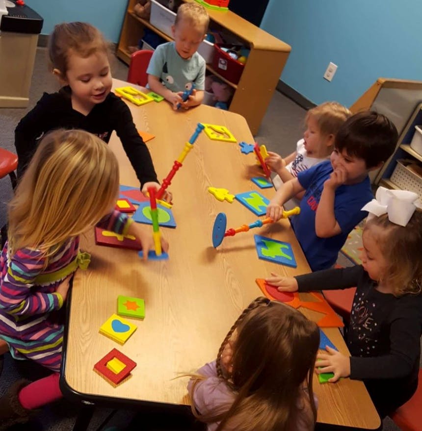 Children playing with colorful building toys at a table