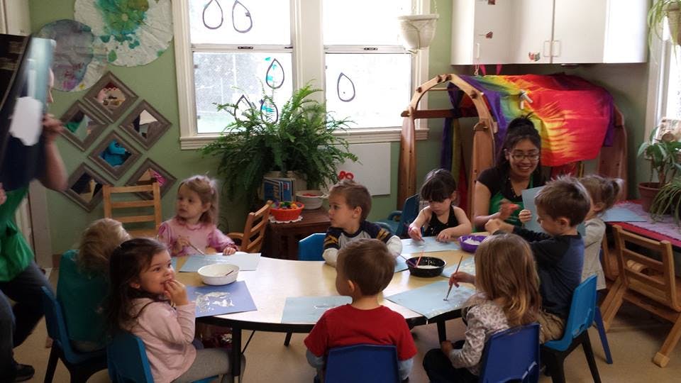 Adult and children sitting around a table in a classroom