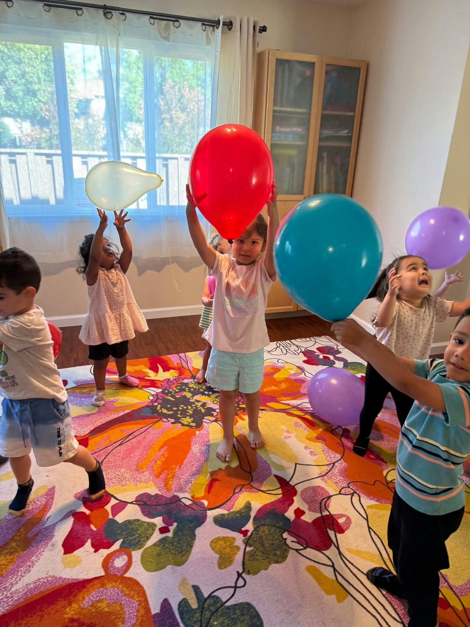 Group of children playing with colorful balloons in a room