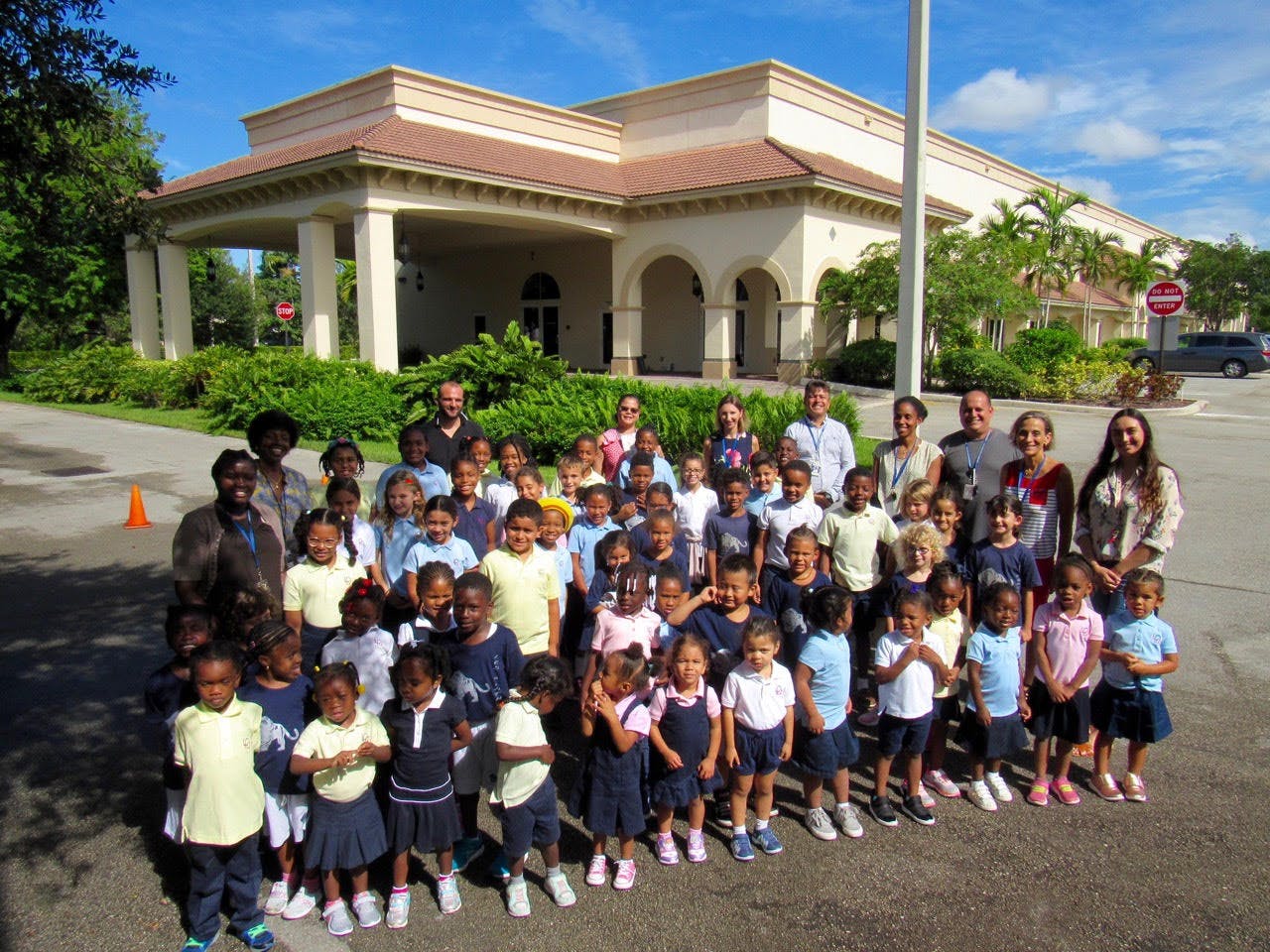 Group of adults and children standing in front of a building