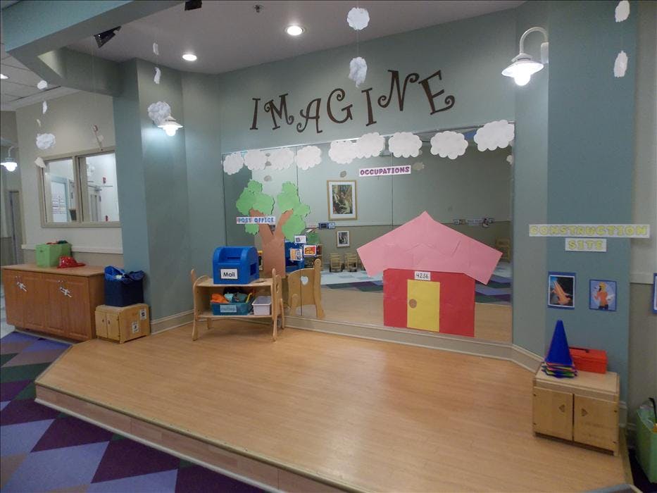 Play area with a mirror wall, words Imagine, and various play props