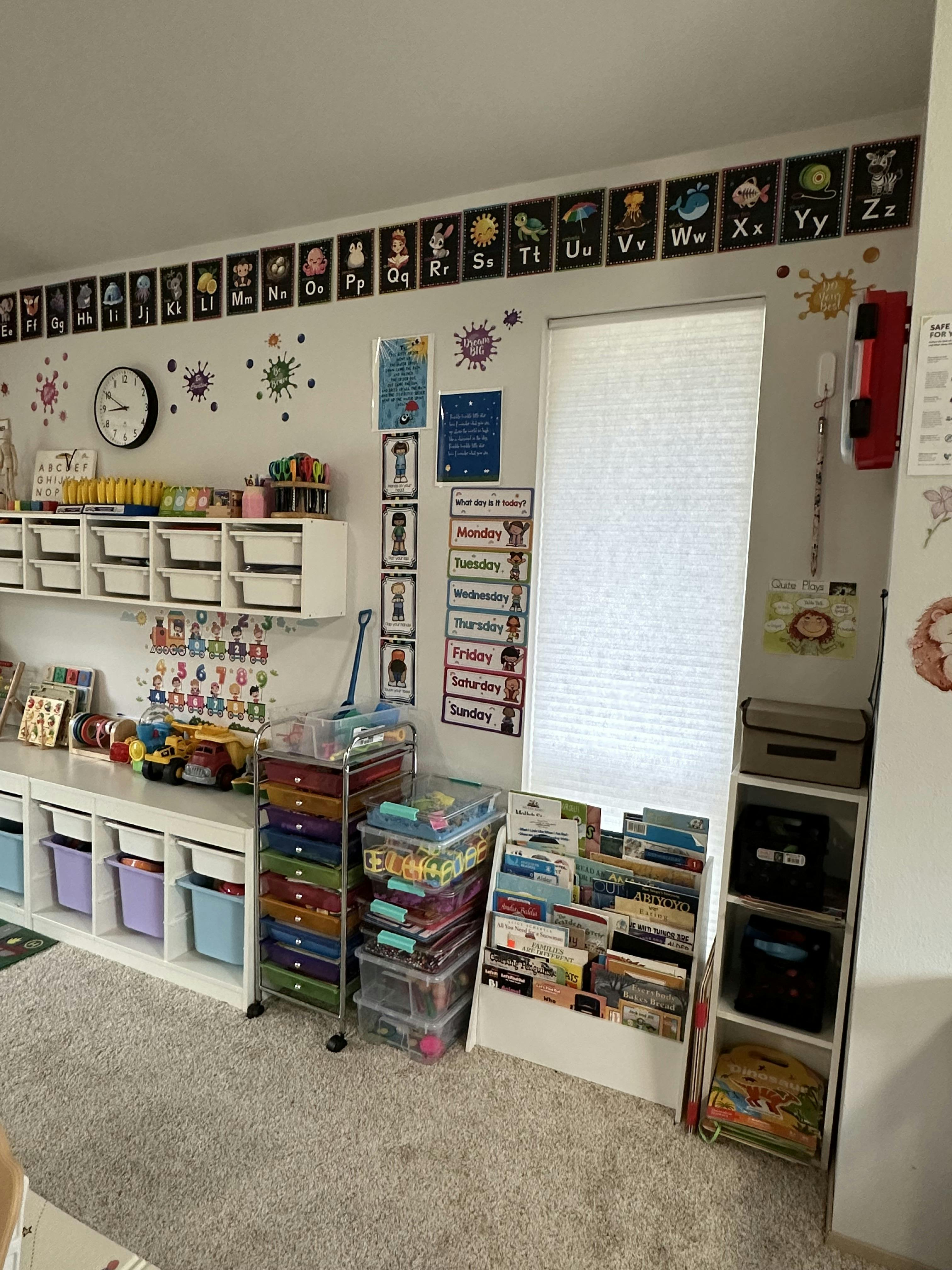 Classroom interior with educational posters, storage shelves, and book displays