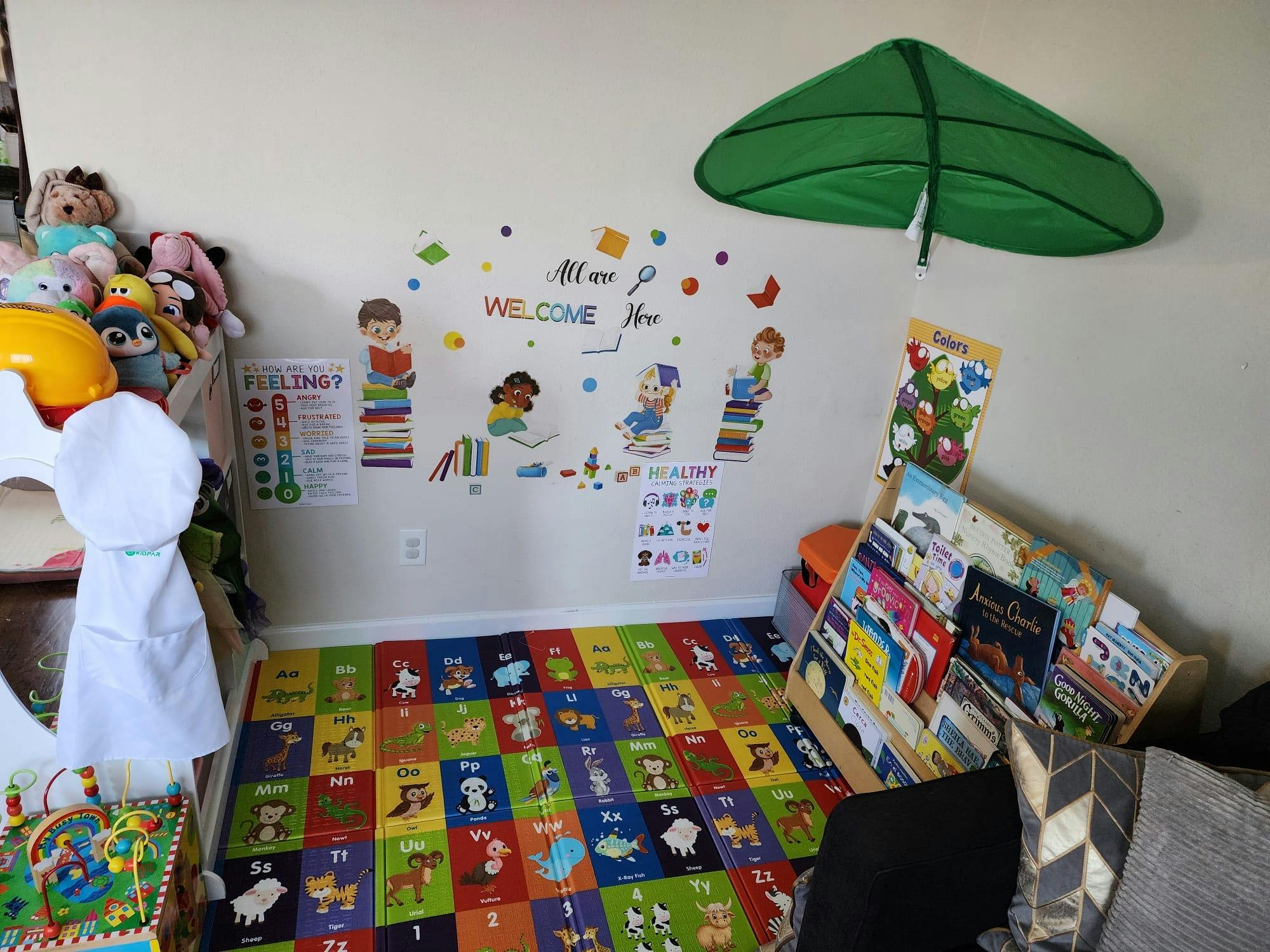 Playroom with alphabet mat, wall decals, and book display