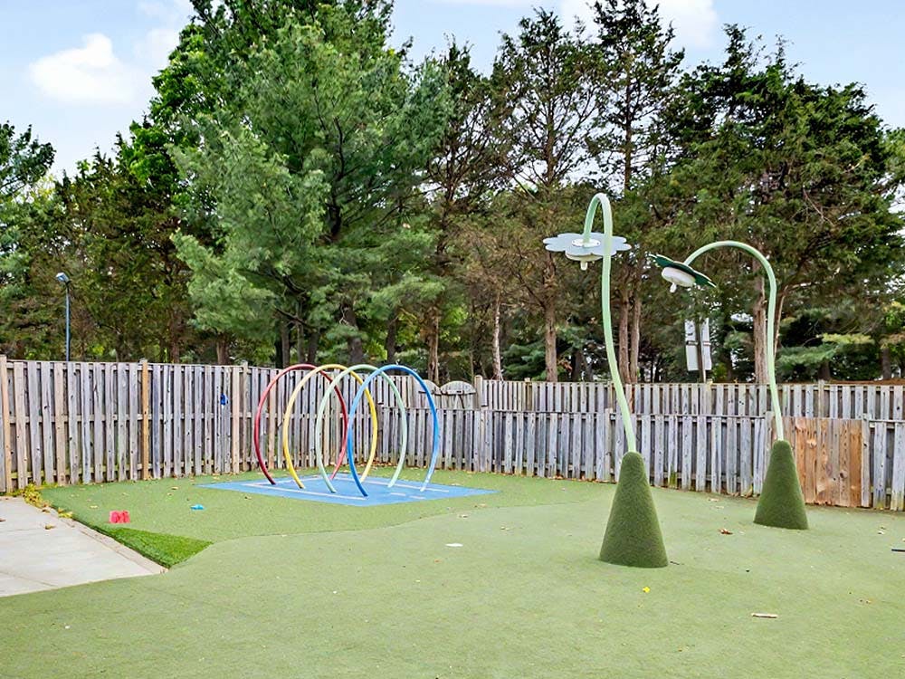 Colorful hoops on artificial turf with flower-shaped water sprayers