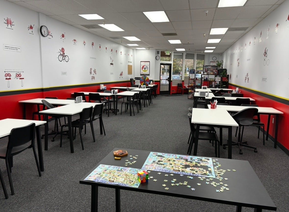Classroom with multiple tables and chairs, wall decorations