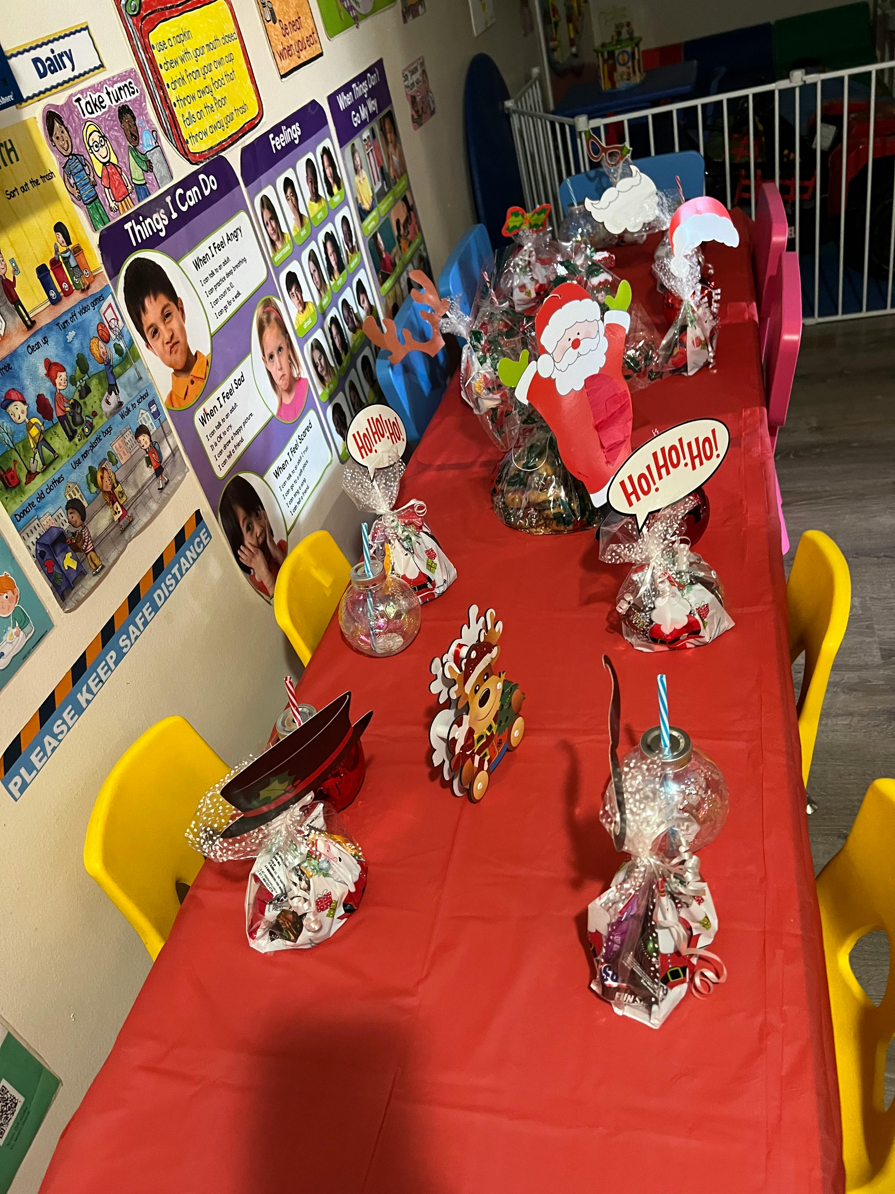 Table with red tablecloth and various holiday-themed decorations and gifts