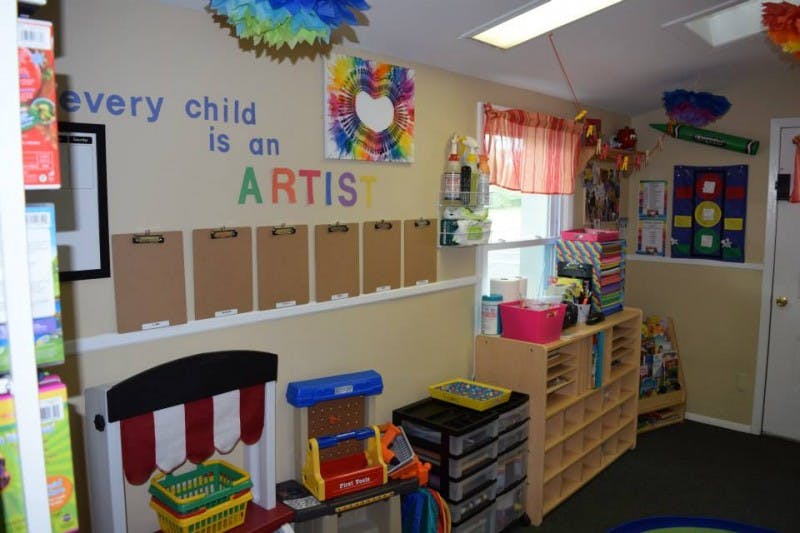 Classroom with "every child is an ARTIST" on wall, art supplies, and cubbies