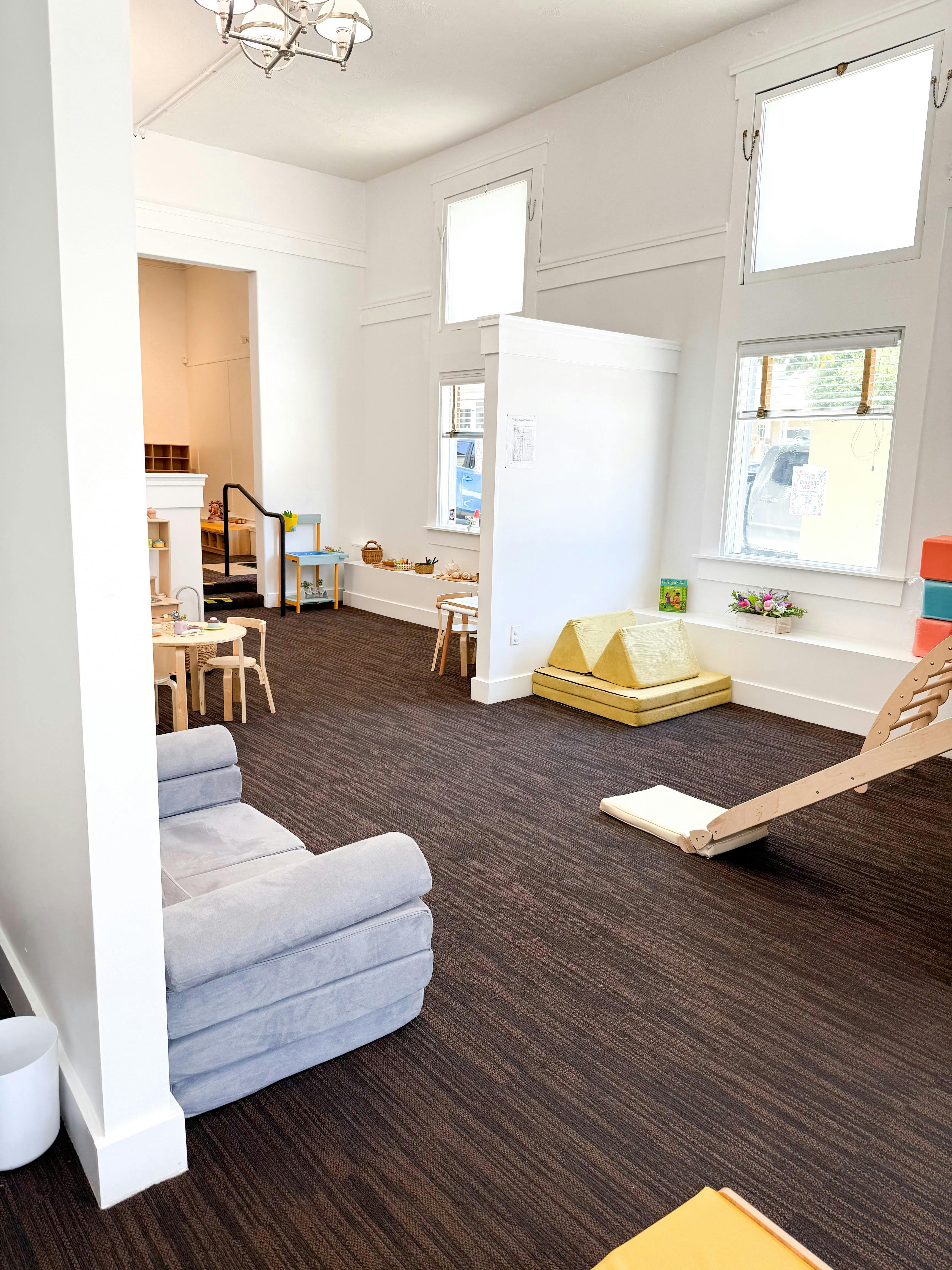 Spacious child play area with small furniture and foam climbing equipment