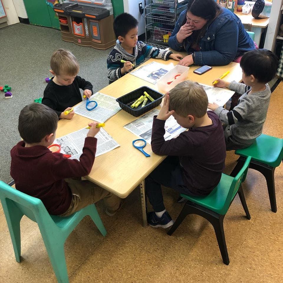 Adult and children sitting at a table drawing