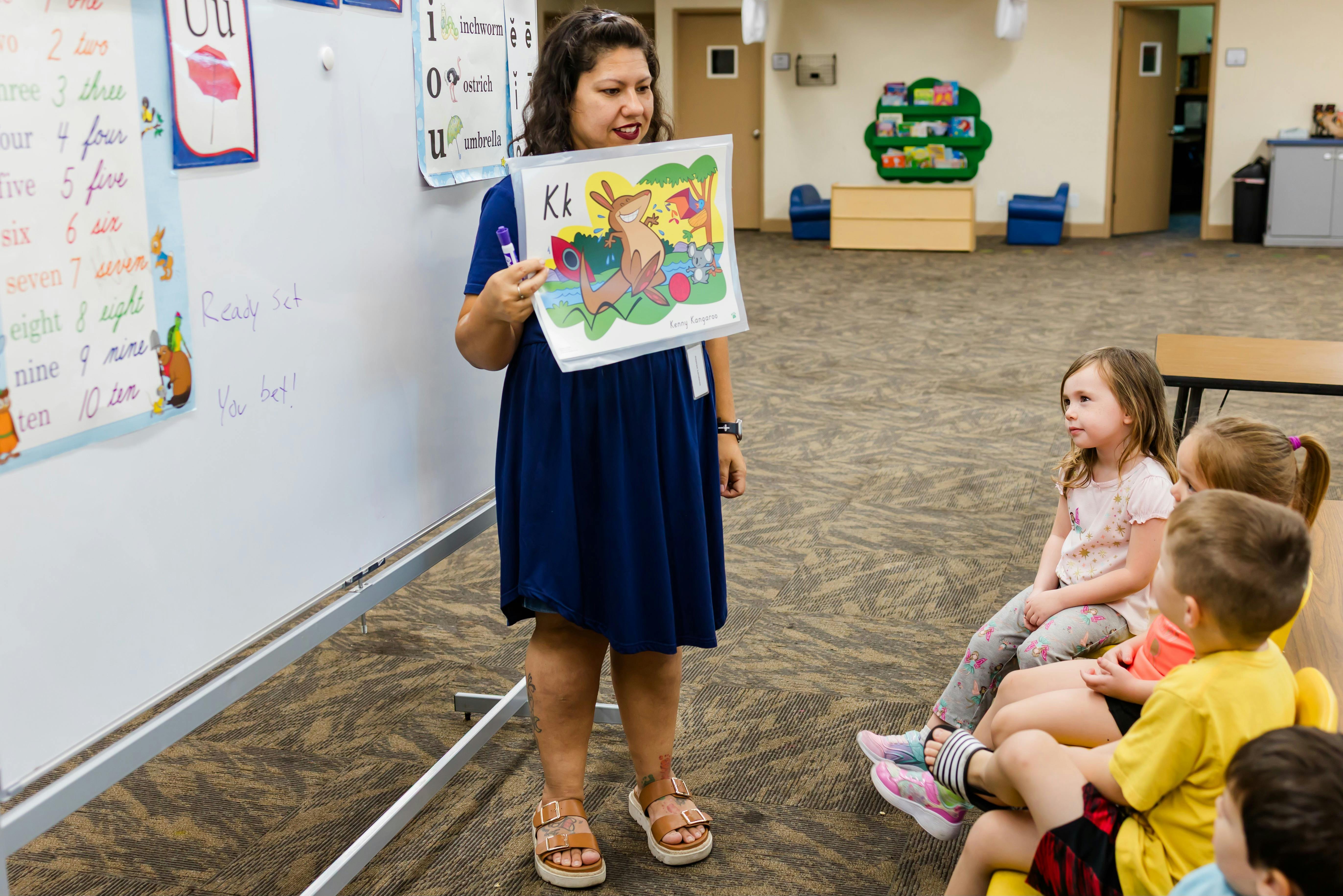 Person holding up a picture book to a group of children
