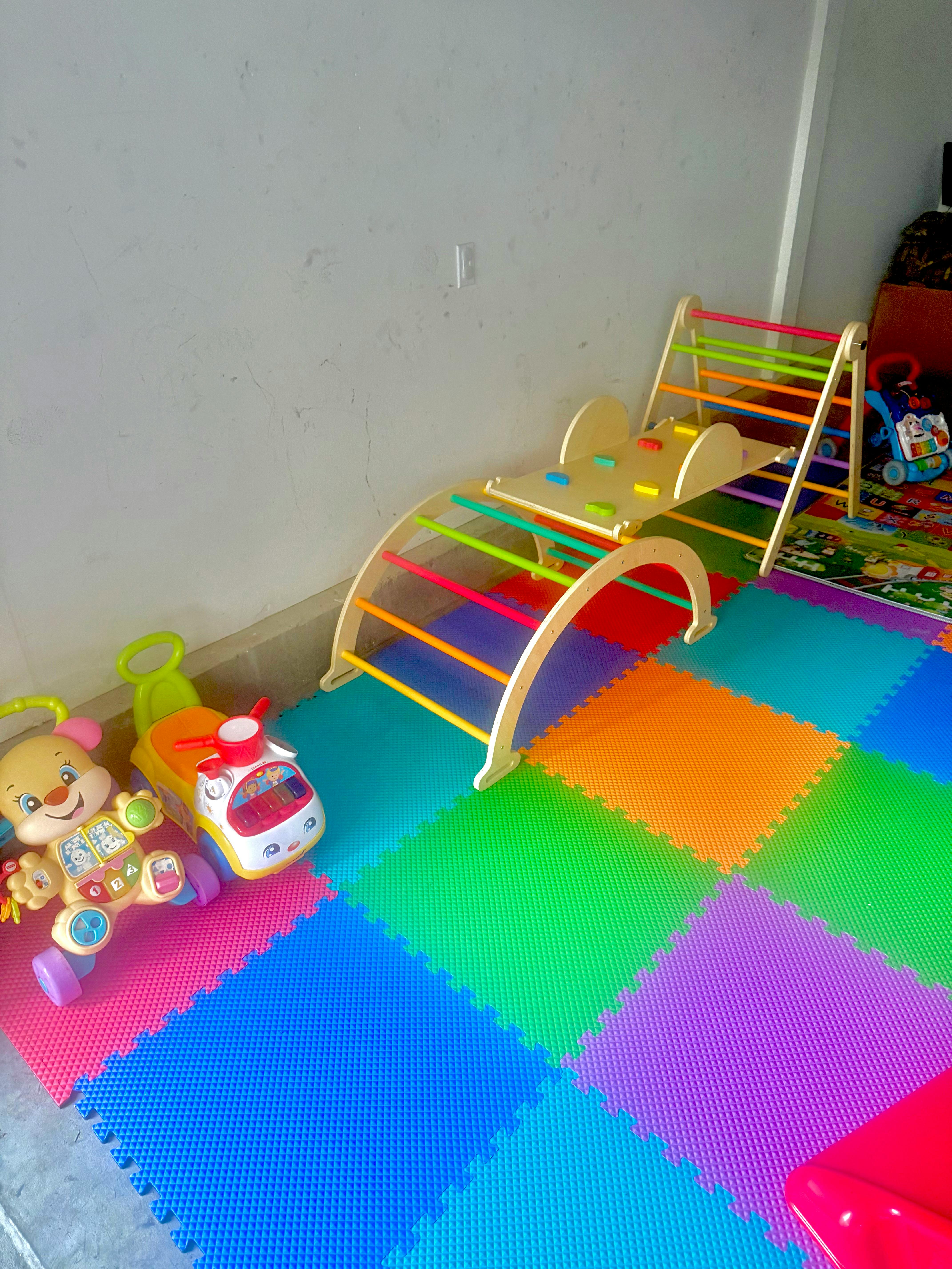 Indoor playground with climbing arch, slide, and colorful floor mats