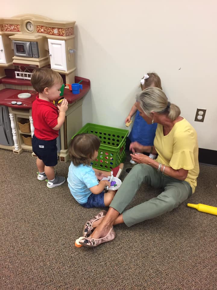 Adult and children playing with toys in a room