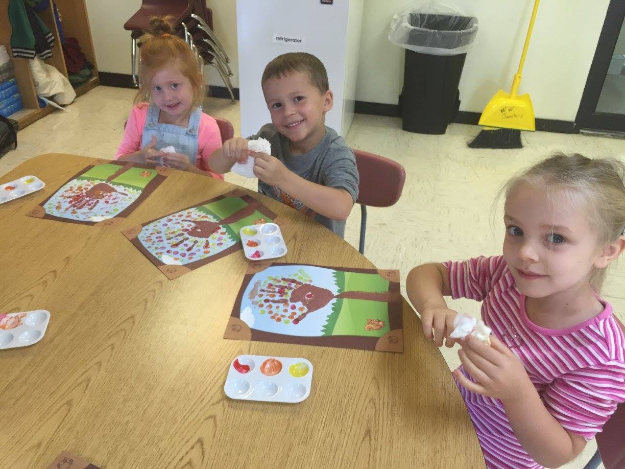 Three children at a table doing an art project