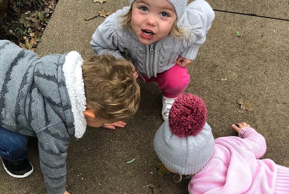 Three children on the ground, one looking up