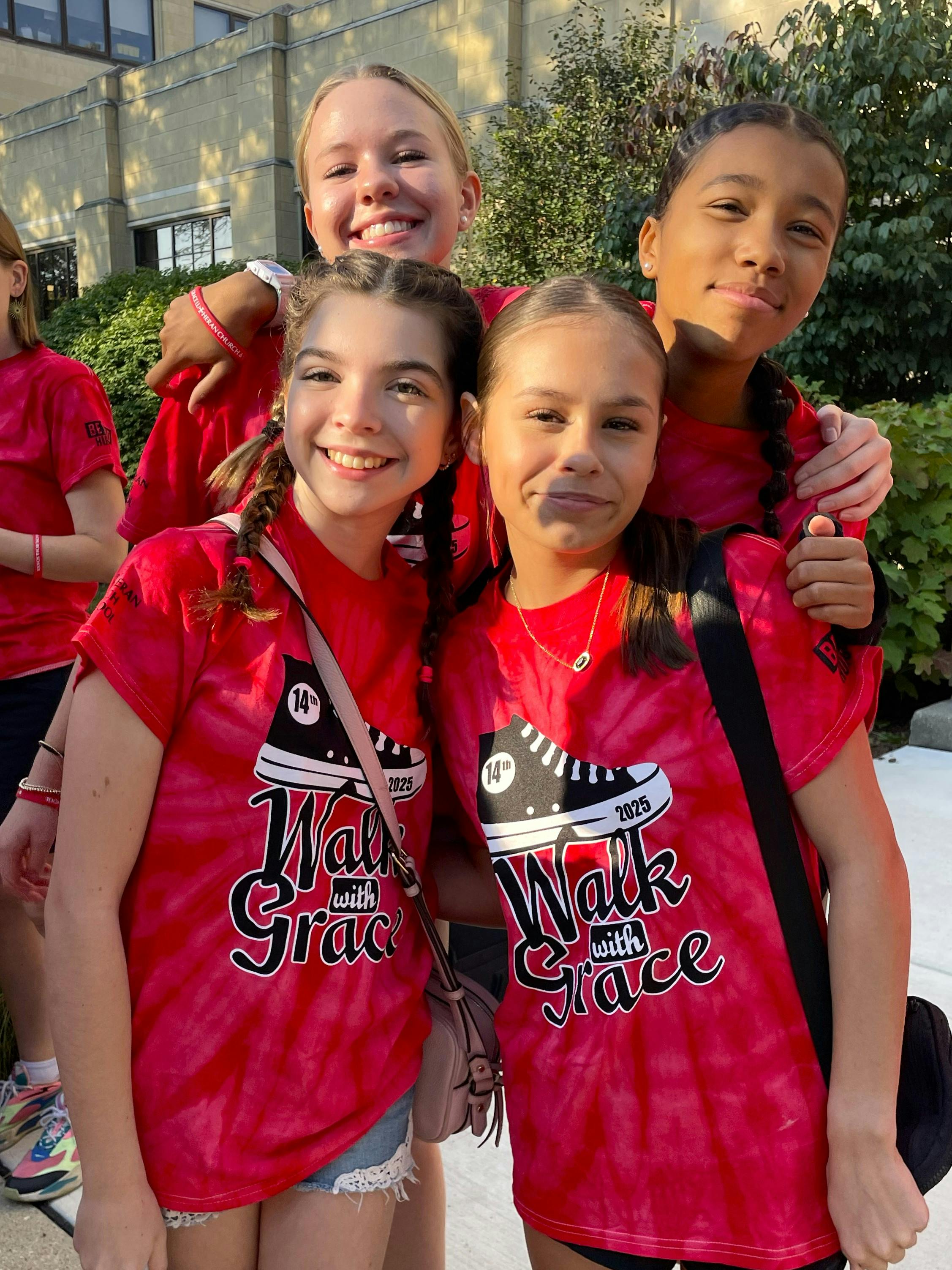 Four teens in red Walk with Grace t-shirts posing together