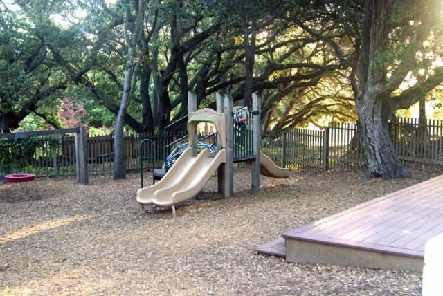 Playground with slides and wood chips under trees