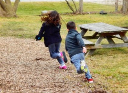 Two children running outdoors