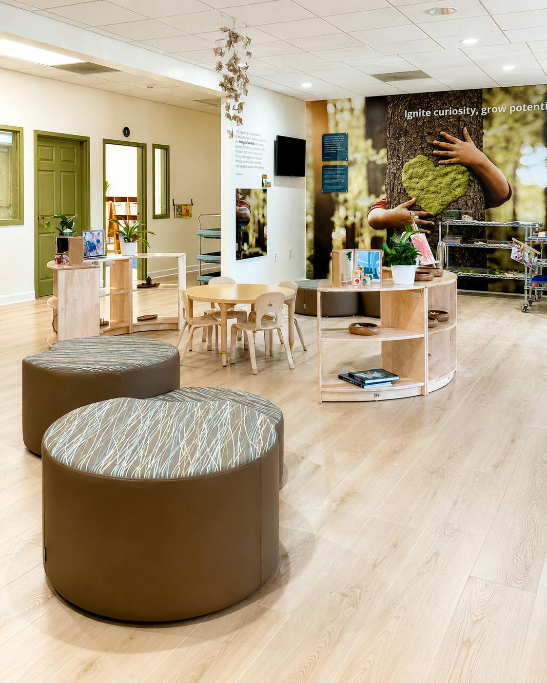 Classroom interior with circular furniture and a mural of a person by a tree