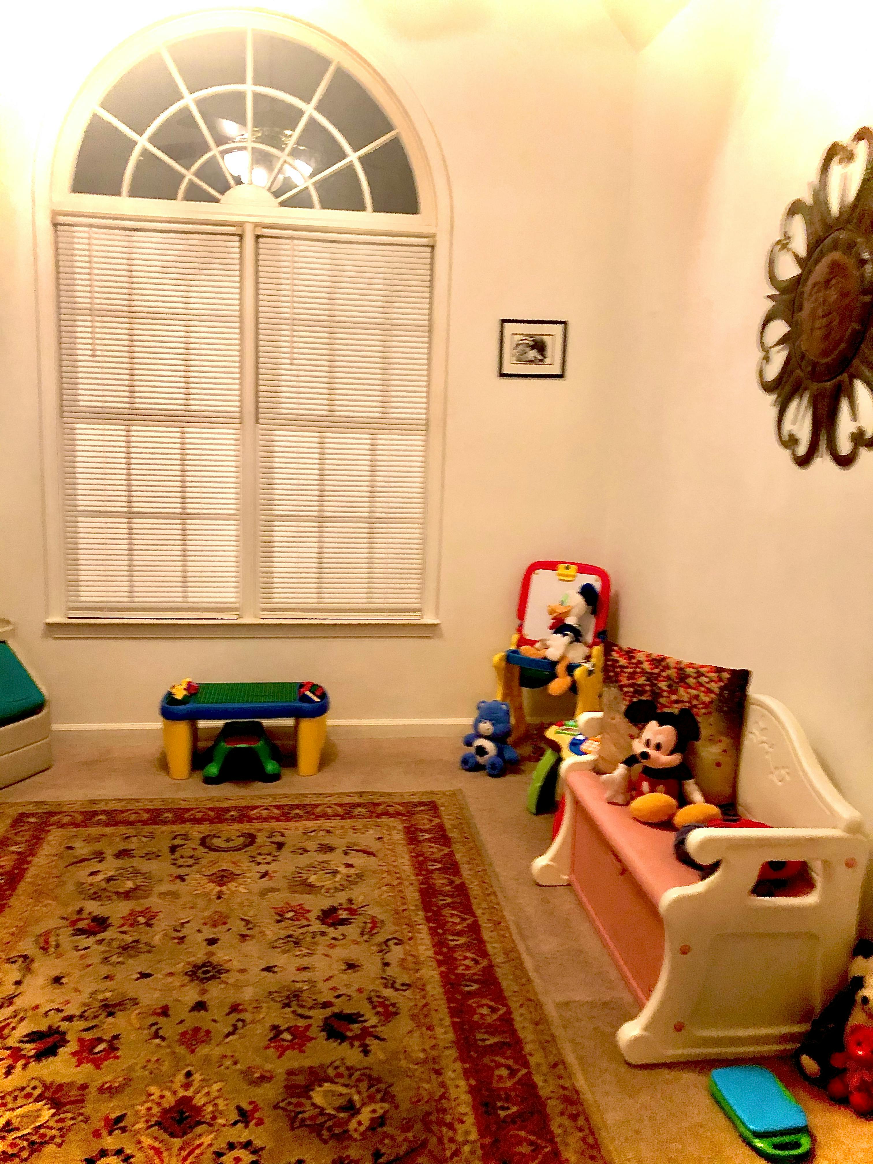 Playroom with window, rug, and toys