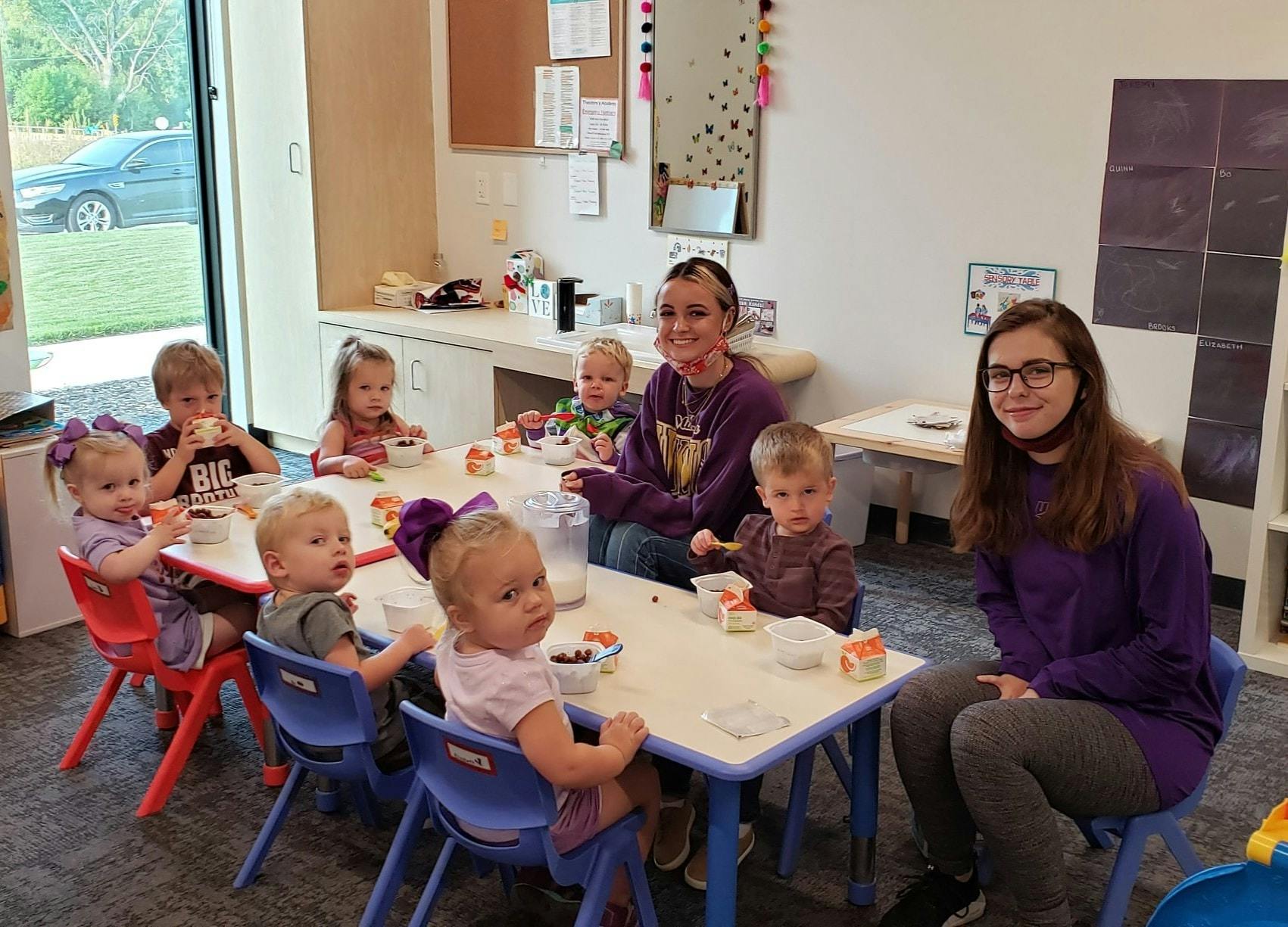 Two people with multiple children sitting at tables