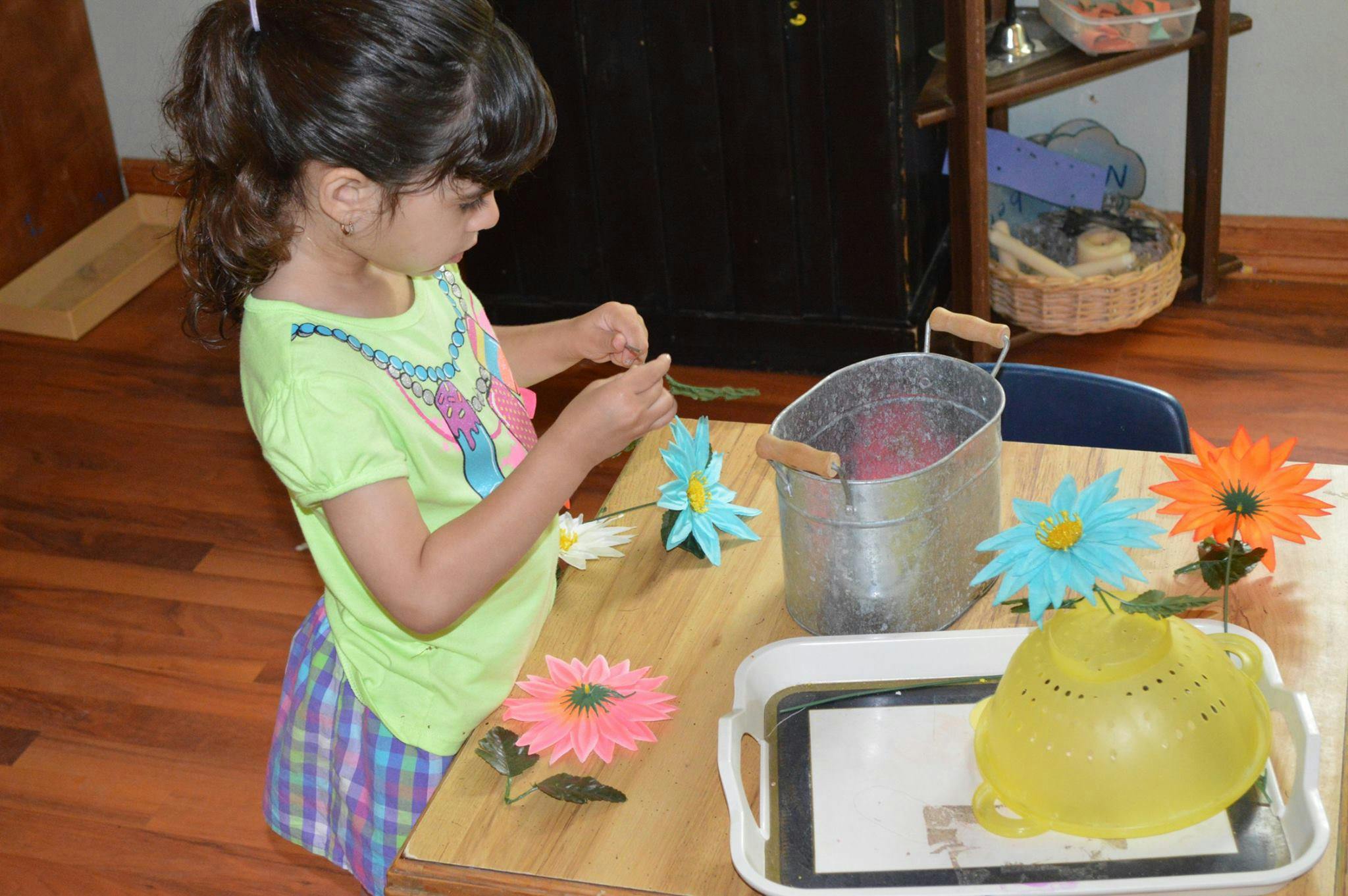 Child working with artificial flowers on a table