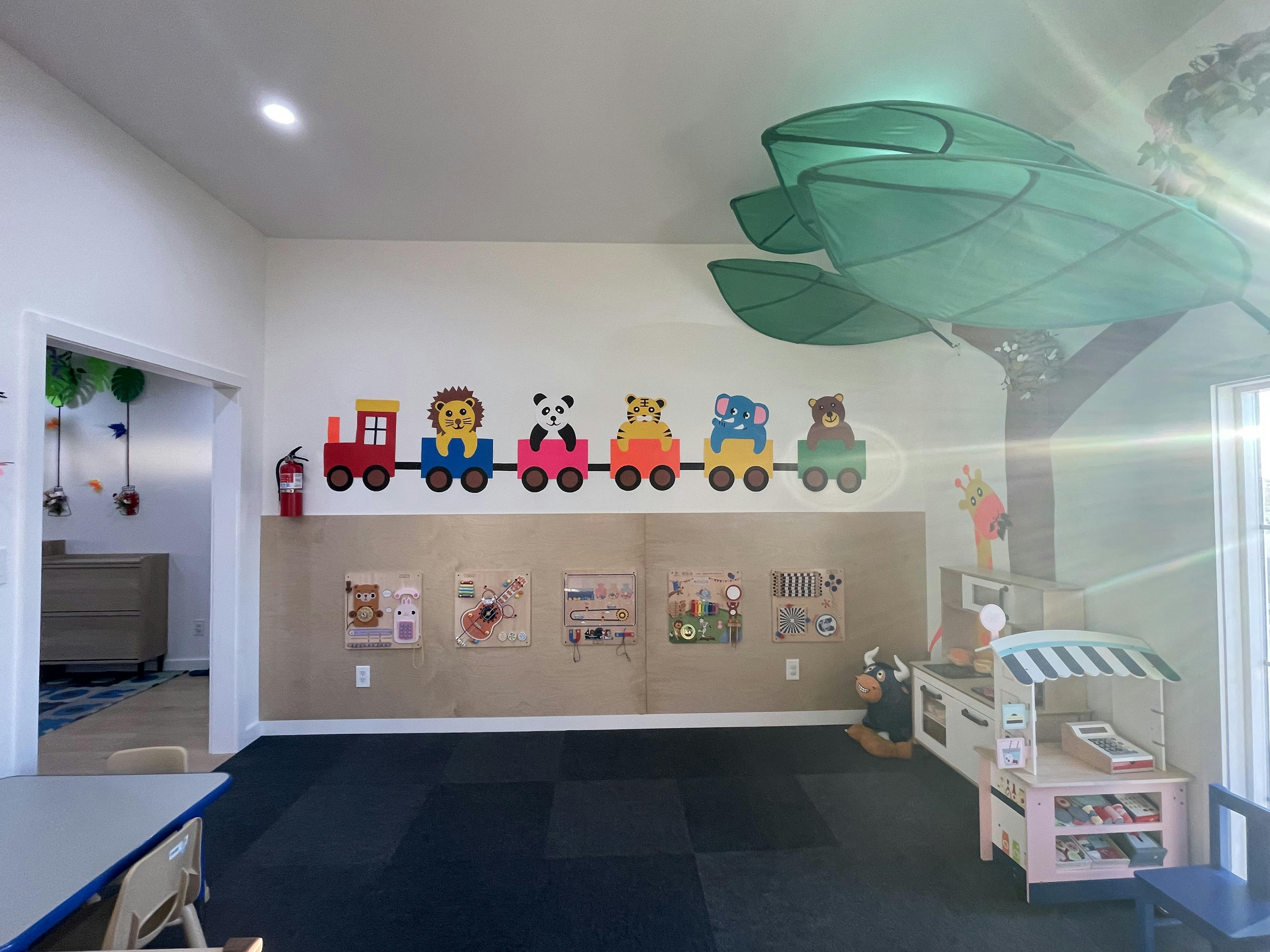 Playroom with animal train decoration and children's artwork on a bulletin board