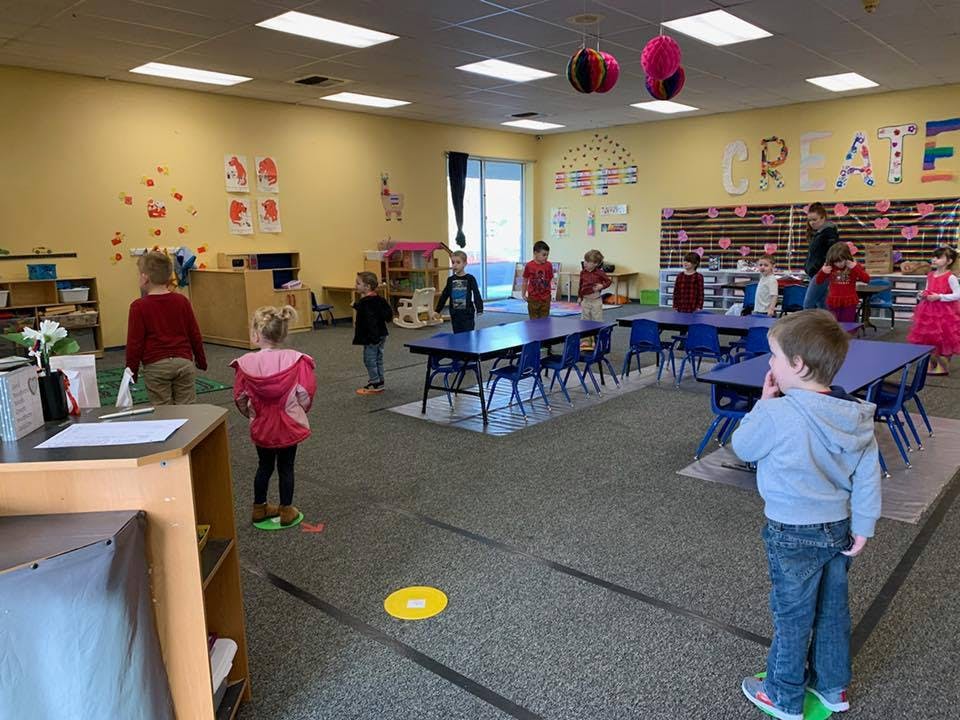 Children in a classroom with tables and chairs