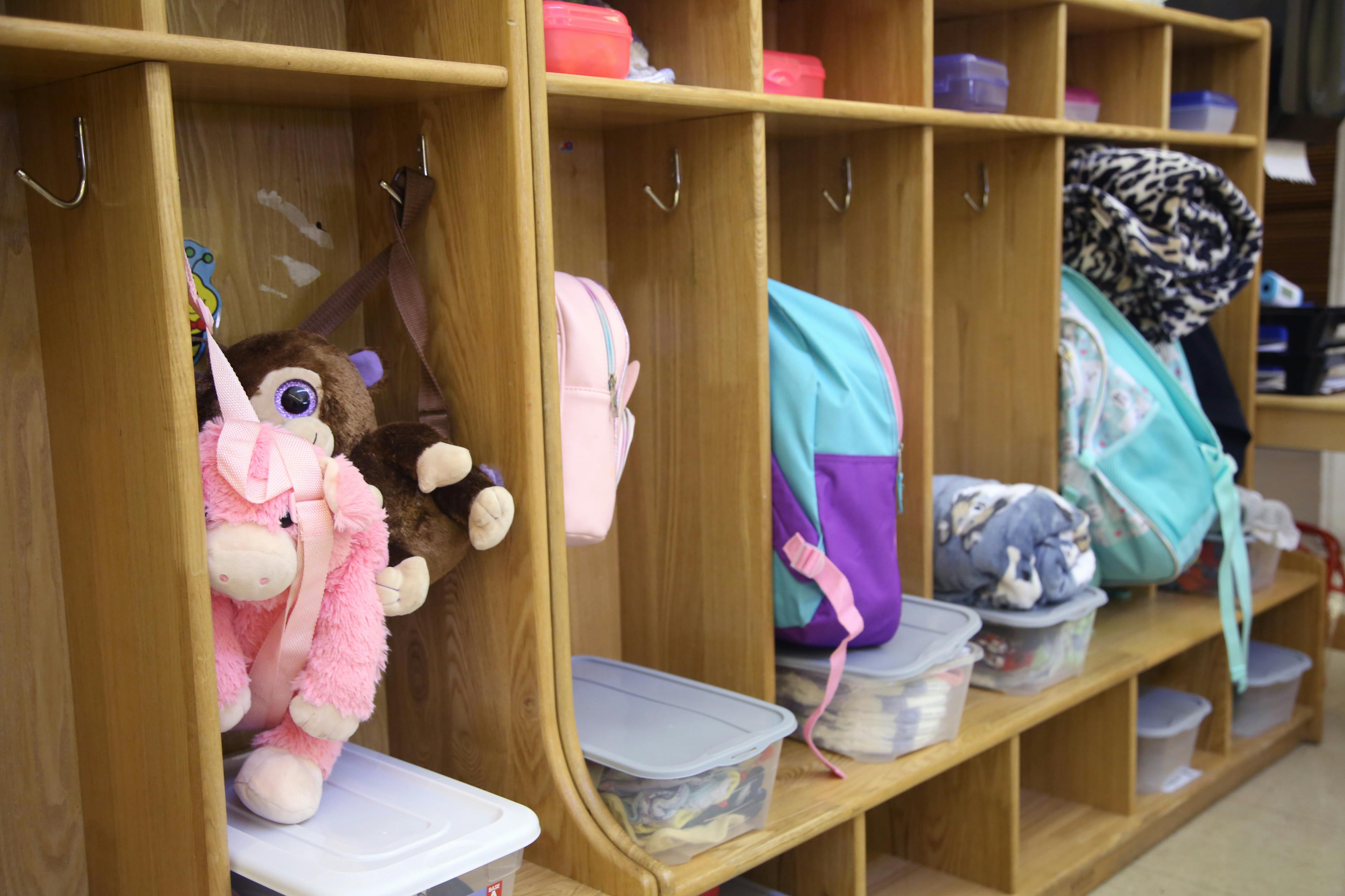 Cubby shelves with backpacks, stuffed animals, and storage containers