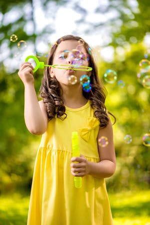 Child blowing bubbles with a bubble wand