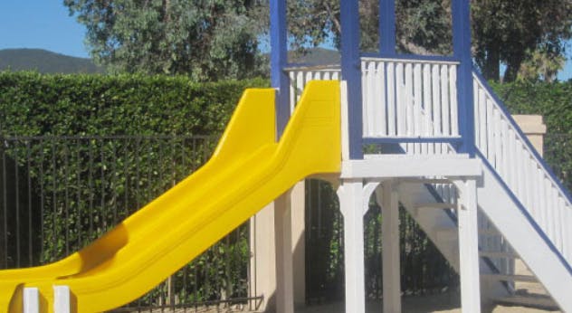 Yellow slide and white stairs on a playground structure