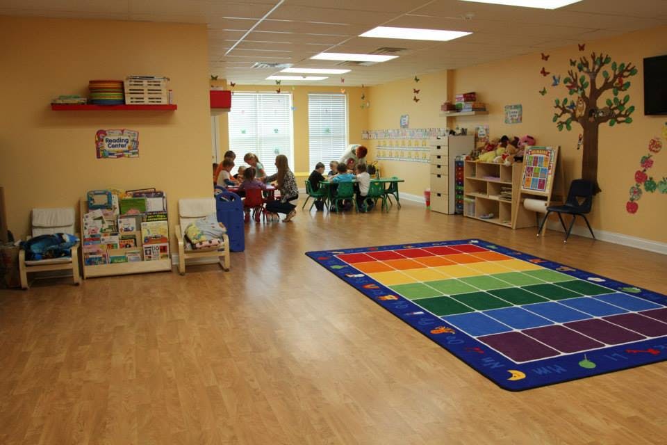 Adults and children gathered around tables in a classroom