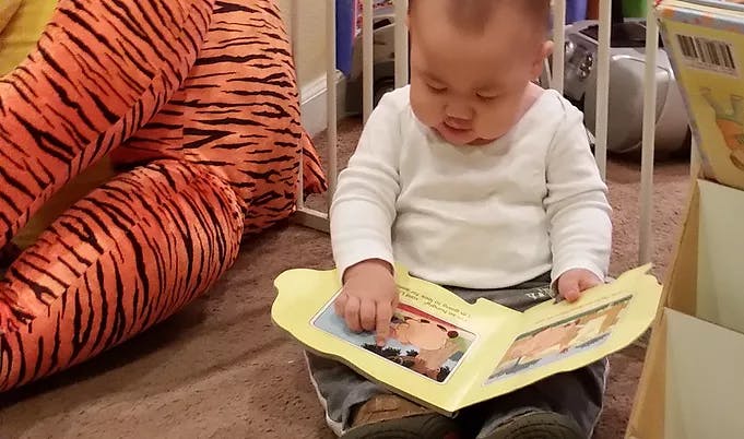 Child sitting on floor looking at a book