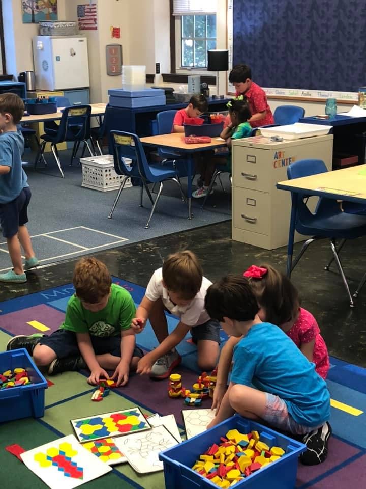 Children playing with colorful blocks on a rug in a classroom